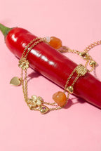 Bedelarmband met oranje kralen, bloemen en hartjes